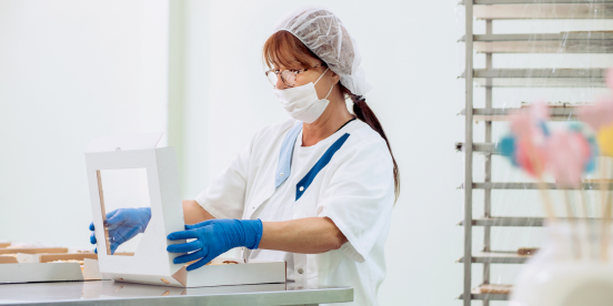 Food production worker boxing up products