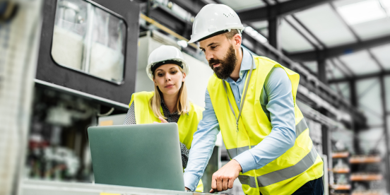 Two co-workers engage in workforce planning at a factory